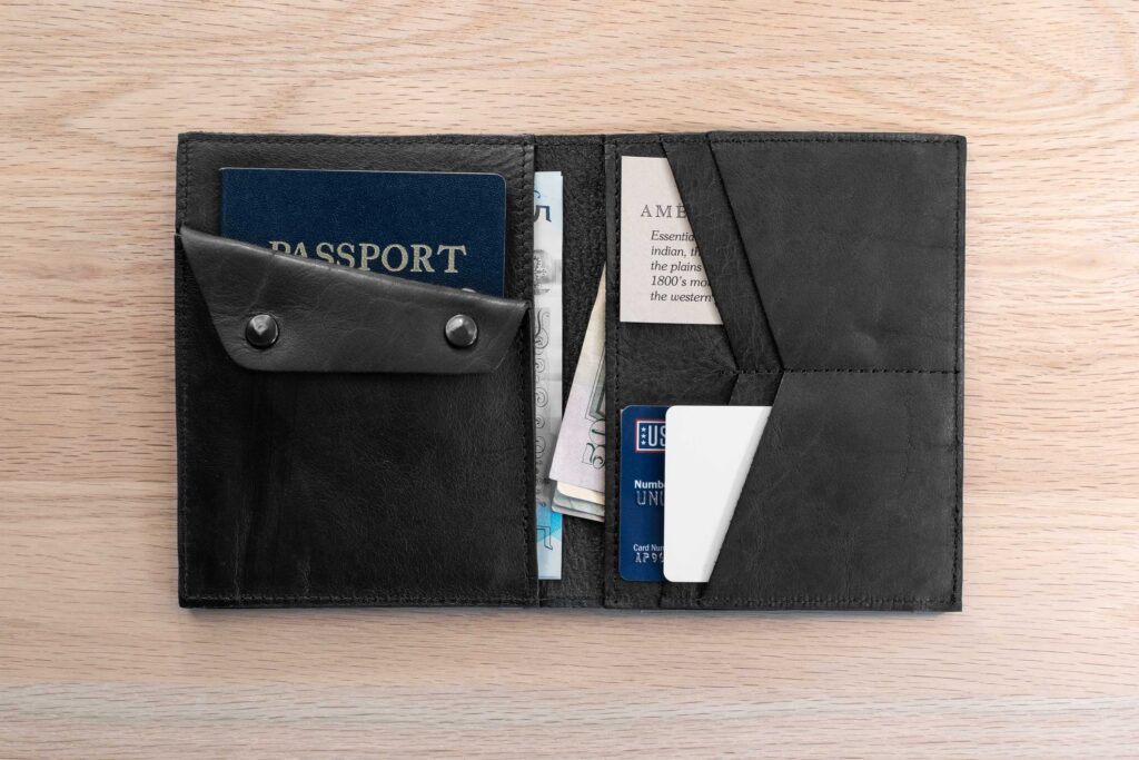 Inside Of Black Leather Passport Wallet Showing Four Card Slots, Two Bill Slots, A Passport Slot, And Coin Pouch.