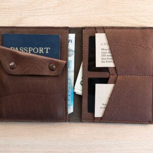 Inside of brown leather passport wallet showing four card slots, two bill slots, a passport slot, and coin pouch.