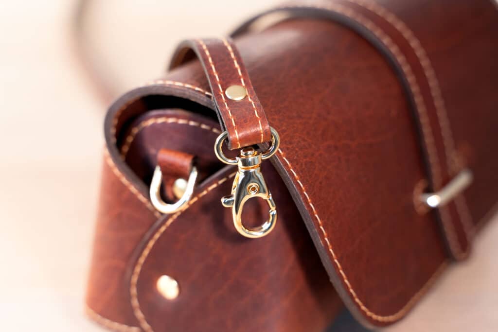 Brass Clip on leather strap of Mini Crossbody Bag in Red Leather