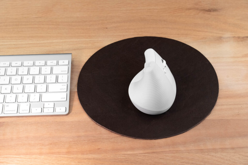 Brown Round Leather Mouse Pad Next To Apple Keyboard