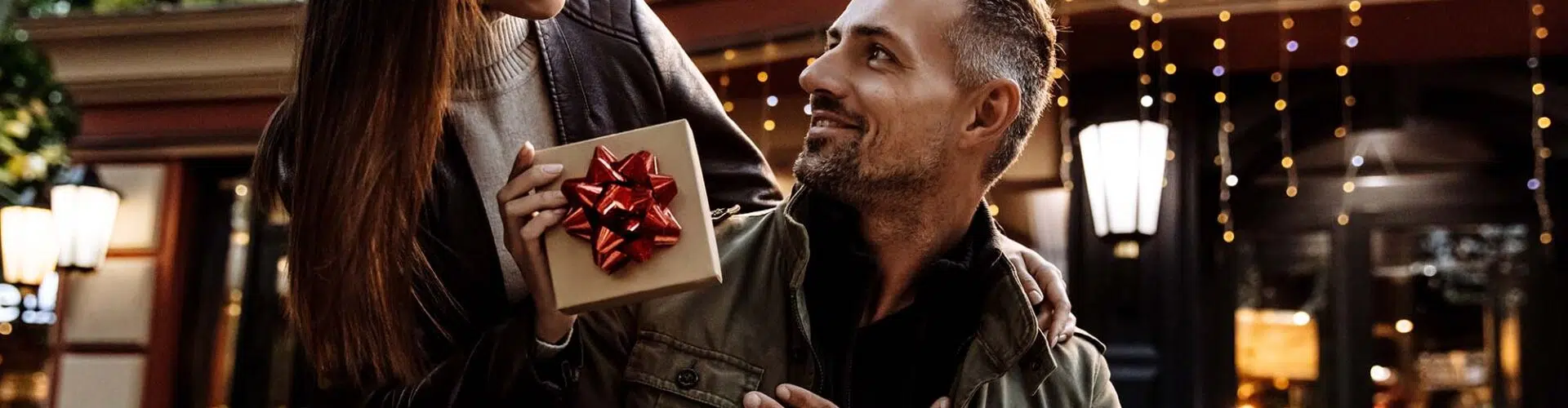 Woman giving man leather anniversary gift